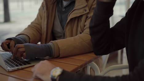 multiethnic men using laptop and smartphone in cafe