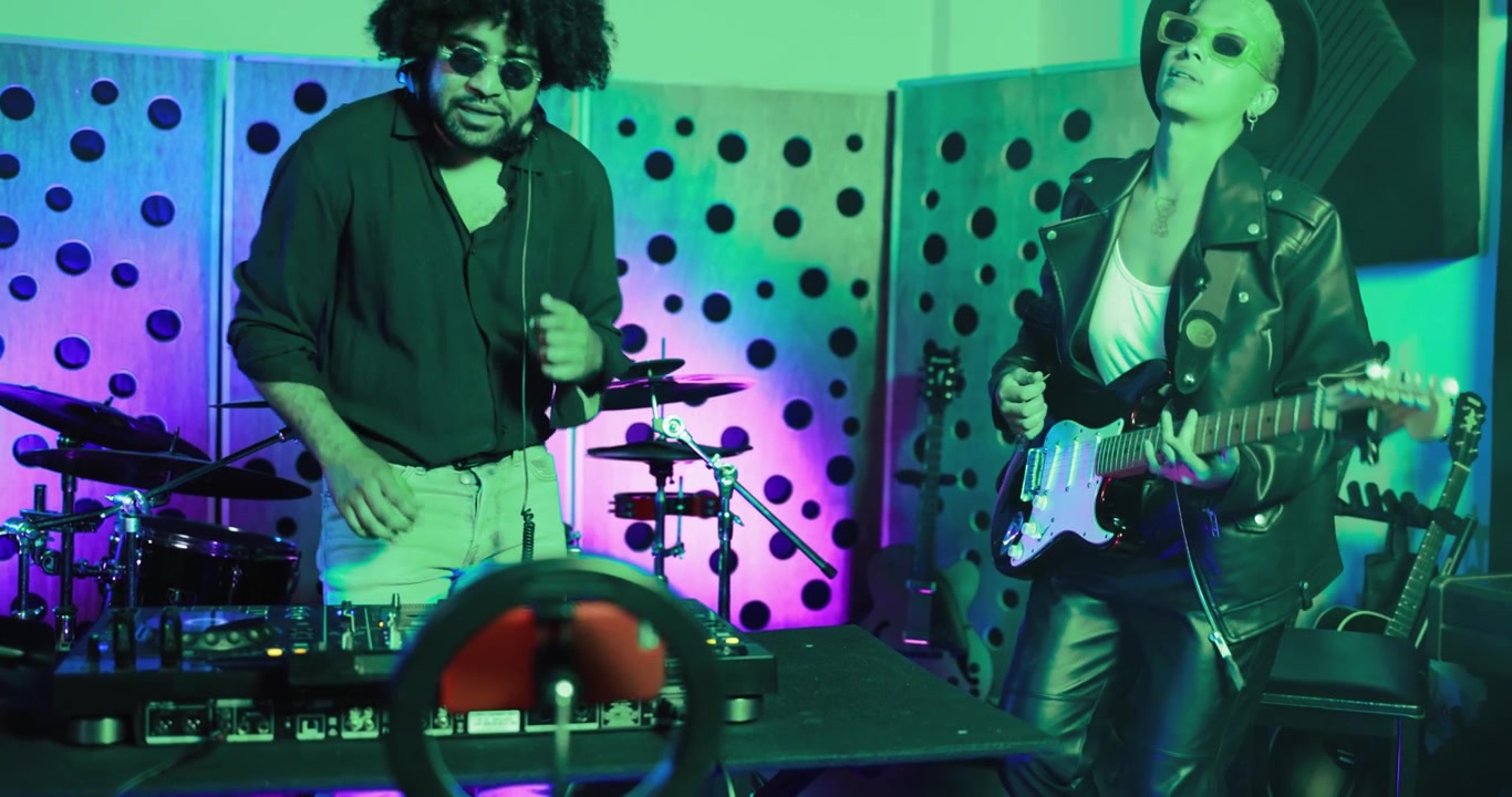 DJ and Guitarist Performing in a Neon Lit Music Studio