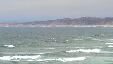 Parapentes-Saltando-De-Las-Dunas-De-Arena-Ventosas-De-Seaside,-California-A-Lo-Largo-De-La-Playa-De-La-Ciudad-De-Arena