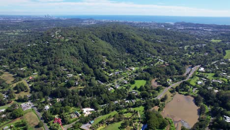 community surrounded with lush forests in currumbin valley, gold coast, qld, australia - aerial drone shot