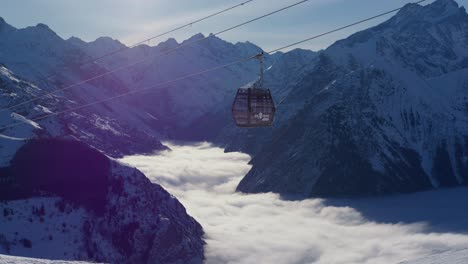 Statisches-Video-Einer-Seilbahn,-Die-An-Einem-Sonnigen-Tag-Auf-Die-Schneebedeckten-Hohen-Berge-Fährt