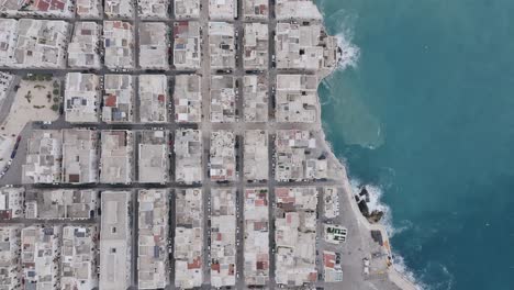 imagen aérea de arriba hacia abajo que muestra la ciudad de polignano una yegua y el mar del mediterráneo