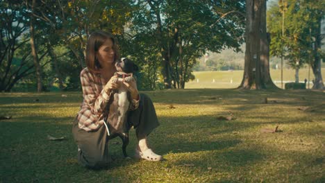 woman and boston terrier in a park