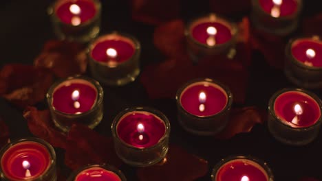 velas rojas románticas encendidas en el fondo cubiertas de pétalos de rosa 1