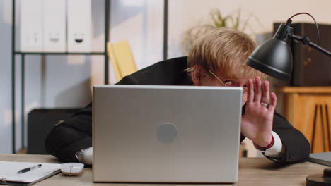 Office-businessman-hiding-behind-laptop-computer-making-funny-silly-face-fooling-around,-disrespect