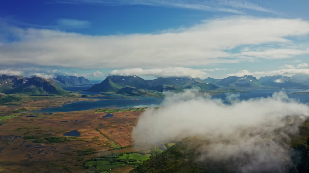 Aerial drone the over the picturesque landscape of the Lofoten Islands in Norway. High view of the green mountains, vast landscape and the blue Norwegian sea. Breathtaking nordic landmark.