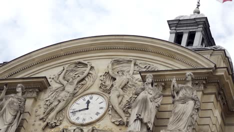 architectural detail of a french building with statues and a flag