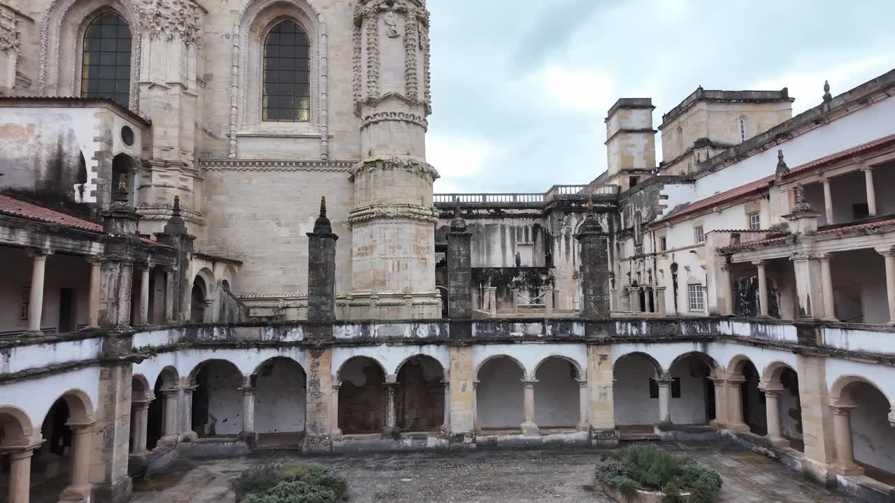 Claustro histórico de Tomar con arcos en un día nublado, Portugal