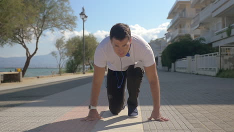 hombre tomando una carrera desde el comienzo de agacharse