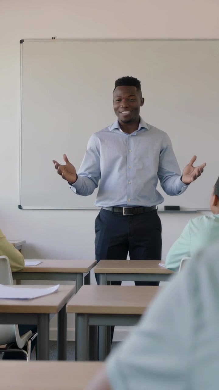 Vertical video: Starting lesson, Black teacher in light blue shirt gesturing at board with papers