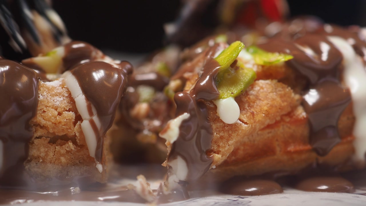Close-up of a Fork Cutting into a Chocolate-Covered Waffle