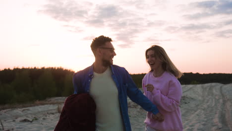 happy couple running in the sand