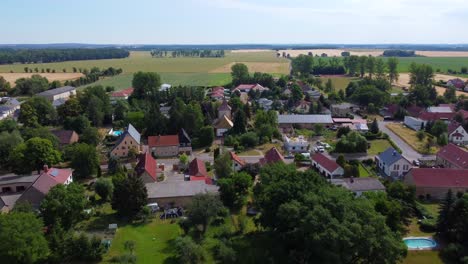 flight to church in the middle of the village great aerial view panorama overview drone footage at countryside hainichen in europe saxony anhalt, summer 4k cinematic view from above by philipp marnitz