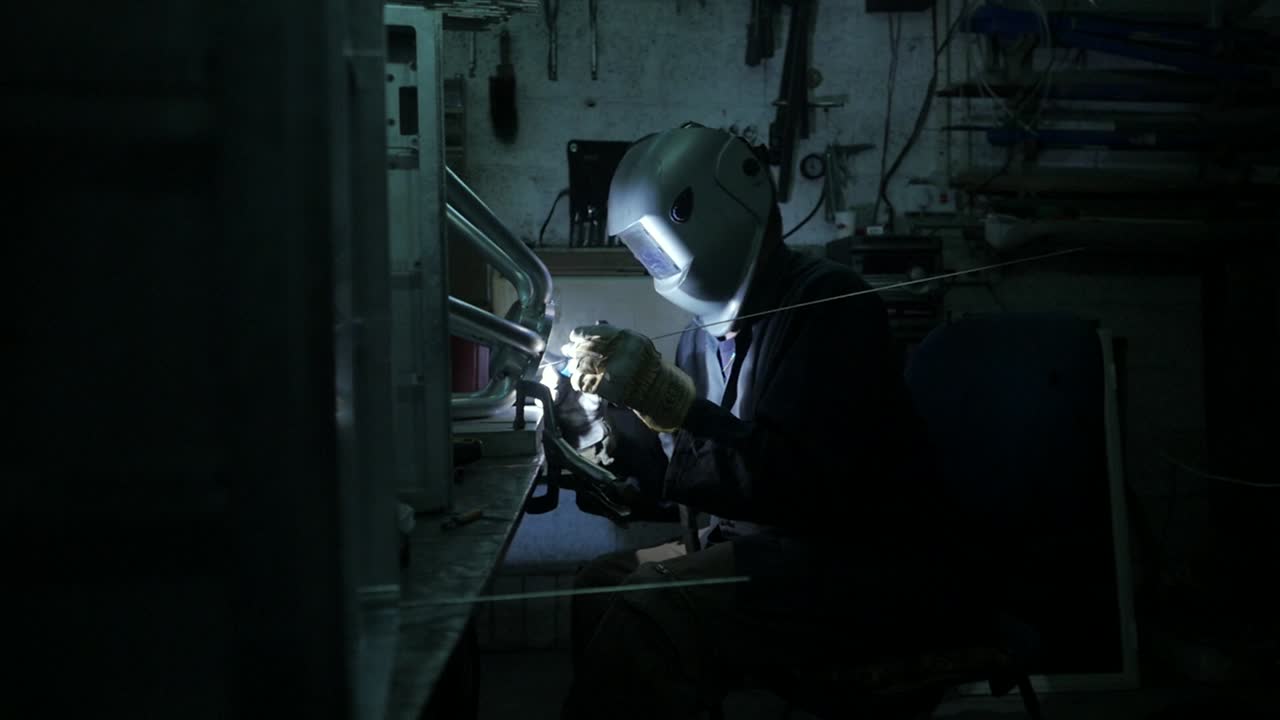 Welder welding an industrial stainless steel part together