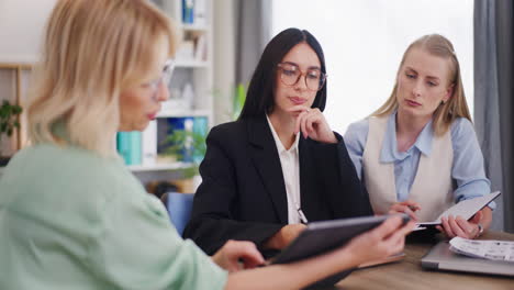 las mujeres discuten la estrategia de ventas durante la reunión de negocios