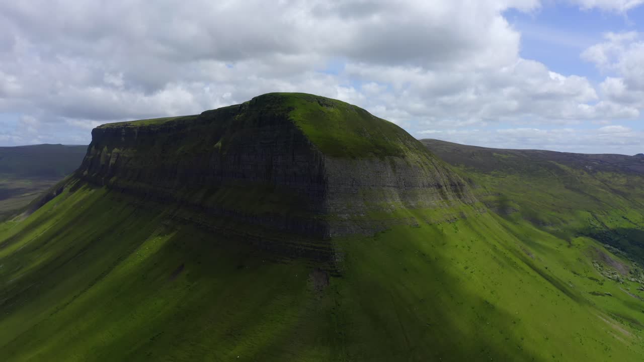 Benbulbin Mountain Sligo, Ireland, June 2021. Drone orbits the south and eastern faces as shadows shroud the slopes ascending to reveal Benwiskin and the Gleniff Horseshoe mountains in the background.