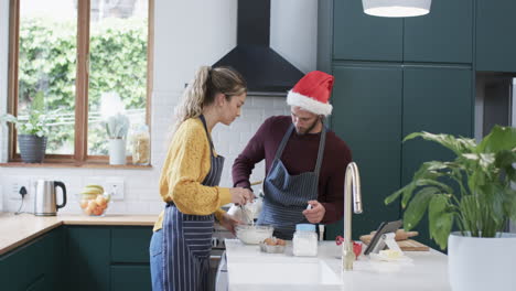 Feliz-Pareja-Diversa-Horneando-Galletas-Navideñas-En-La-Cocina-De-Casa,-En-Cámara-Lenta