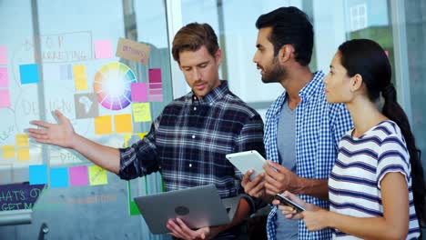 Team-of-executives-discussing-over-sticky-notes