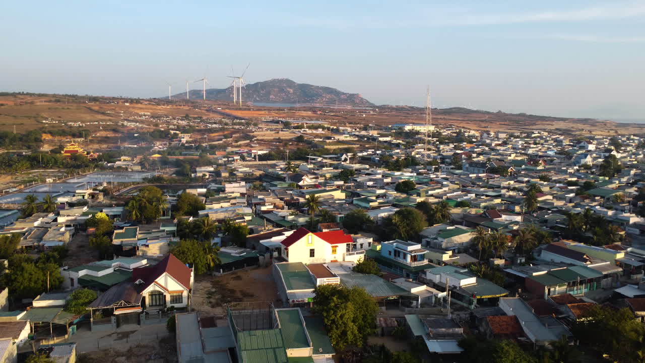 vista aérea de la puesta de sol del remoto campo rural vietnamita de son hai, con una torre de 5 g en el medio del pueblo y una turbina de molino de viento para la producción de energía alternativa sostenible y respetuosa con el medio ambiente