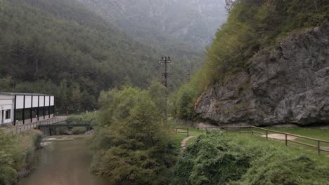 Flying-along-mountain-stream-and-waterfall-with-footpath-for-tourist