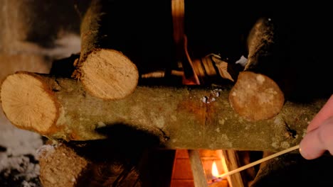 logs of wood being set on fire in the fireplace