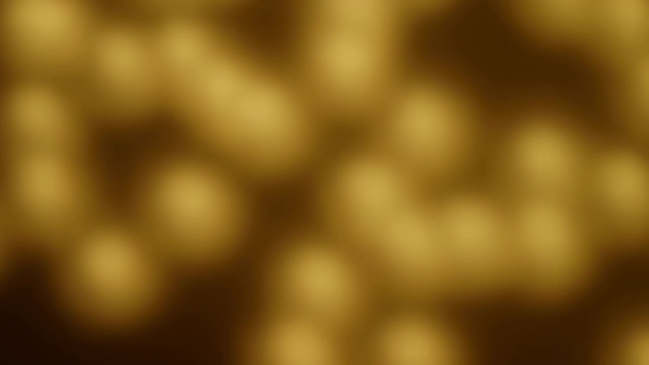 Partículas de oro brillando y resplandeciendo sobre un fondo oscuro, desde un primer plano, con acentos dorados y negros, y un ambiente elegante y lujoso, con objetos cercanos y el entorno circundante.