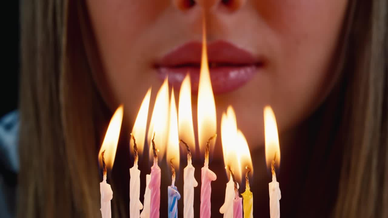 el cumpleañero sopla las velas de un pastel de cumpleaños