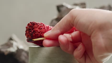person holding palo santo wood stick in hand, aromatic palo santo burning on black background, smoke spreading around, slow motion video clip, high quality 4k close up footage. high quality 4k footage