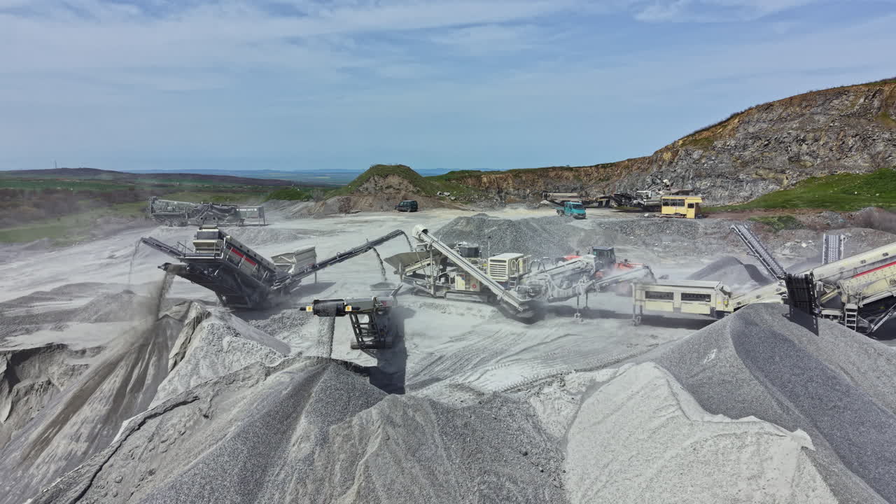 Granite quarry site with machinery working to process stone in an open area during the day