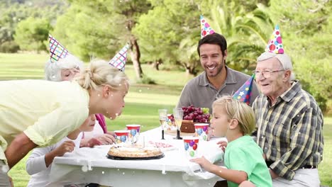 Animation-of-white-spots-over-happy-family-at-birthday-party