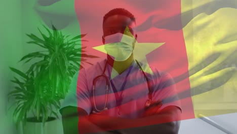 Animation-of-flag-of-cameroon-waving-over-doctor-wearing-face-mask