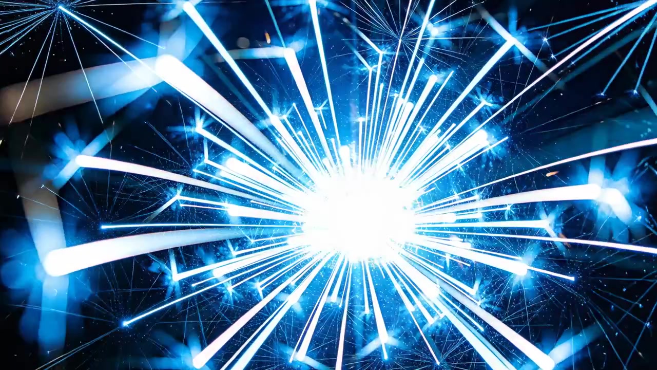 暗い背景に輝く青い中心から放射状の光線が広がり、星々、燃えかすのきらめき、ボケ効果が散りばめられた光点