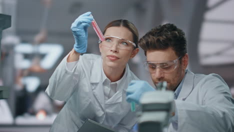 dos investigadores examinando una muestra de vacuna en un laboratorio biotécnico de cerca.