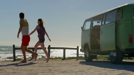 couple holding hands and running towards beach 4k