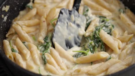 crop person preparing pasta in frying pan