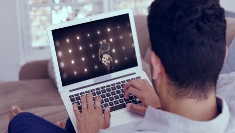 hombre viendo un juego de fútbol en una computadora portátil