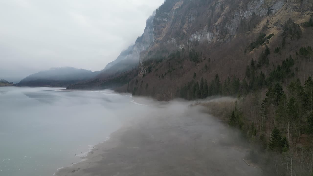 Klöntalersee Glarus Switzerland rising shot above the misty lake beach