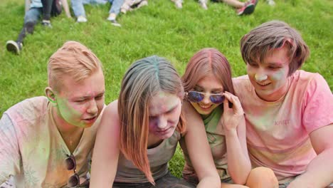 holi festival celebrants watching photos on phone