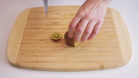 High-angle-shot-of-a-kiwifruit-being-peeled-and-cut-into-chunks