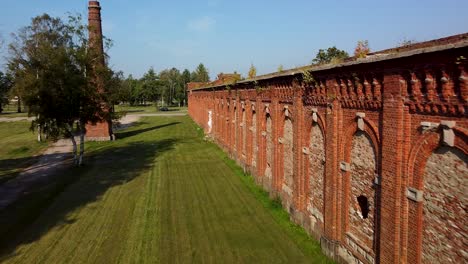 Aerial-view-of-former-russian-tsar-army-gymnastics-hall-in-Karosta,-Liepaja,-used-for-gymnastics-performances-and-competitions-for-horseback-riders,-wide-angle-ascending-drone-shot-moving-forward