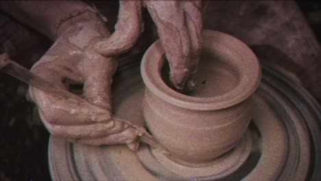 the potter makes a jug of clay. vintage effect. a man makes a vase on a potter's wheel