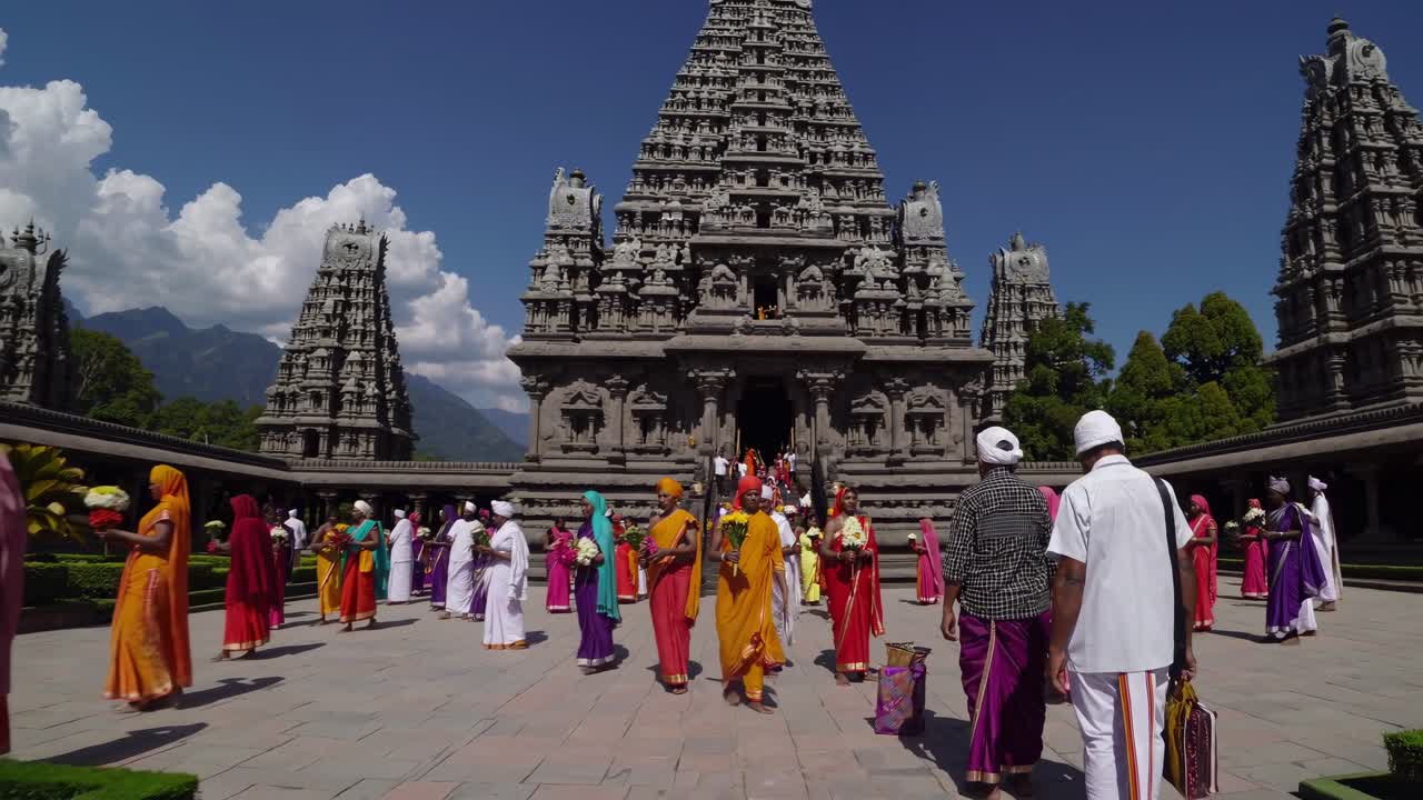 Vibrant scene of colorful attire and joyful participants engaging in a ceremonial gathering, showcasing cultural expressions and community spirit in a majestic temple setting