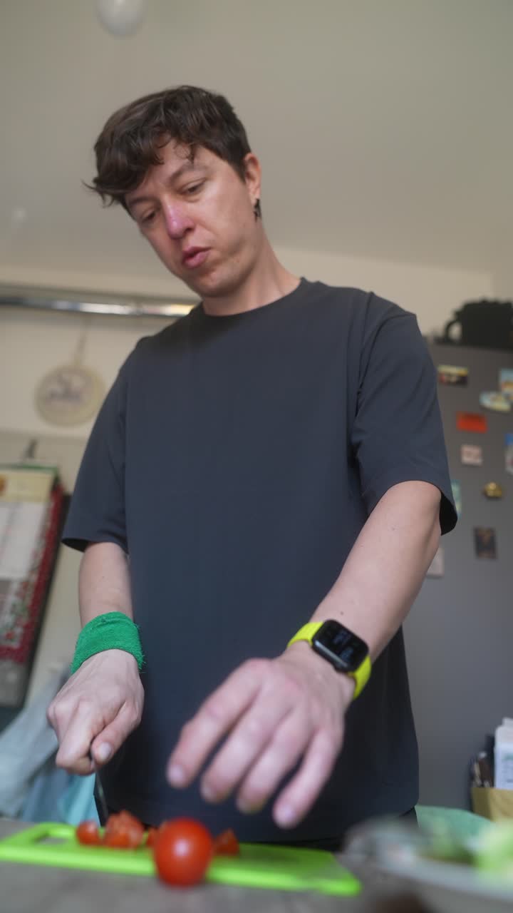 주방 에서 토마토 를 잘라내는 사람