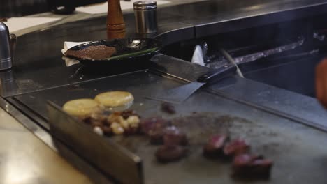 chef cooking meat and vegetables on hot grill