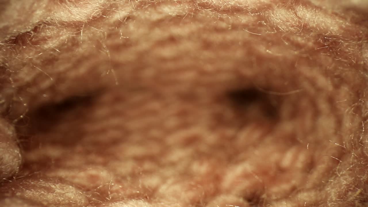 가장자리가 날카 롭고 중앙이 메쉬 패턴과 유사한 얕은 초점으로 수제 분홍색 양말을 꺼냅니다.