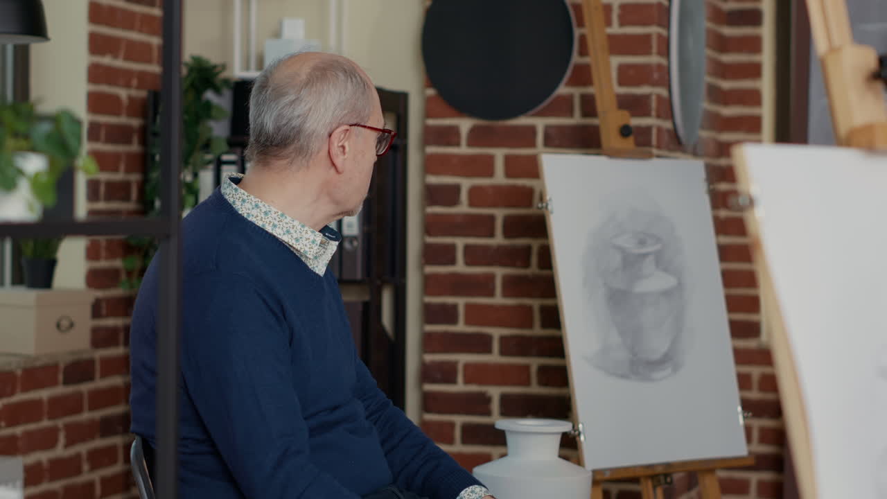 Senior artist showing vase model to people attending workshop practice
