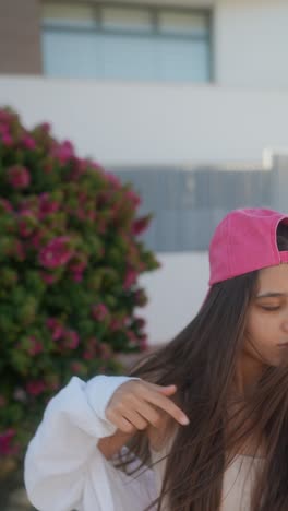 young woman outdoors in pink hat