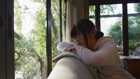 아시아 소녀 가 창문 을 통해 보고 소파 에 누워 있다