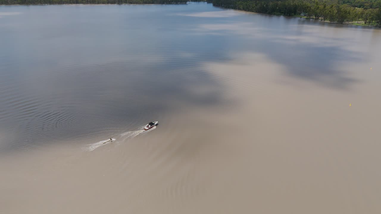 경치 좋은 호수 에서 배 를 견인 하는 스키 선수