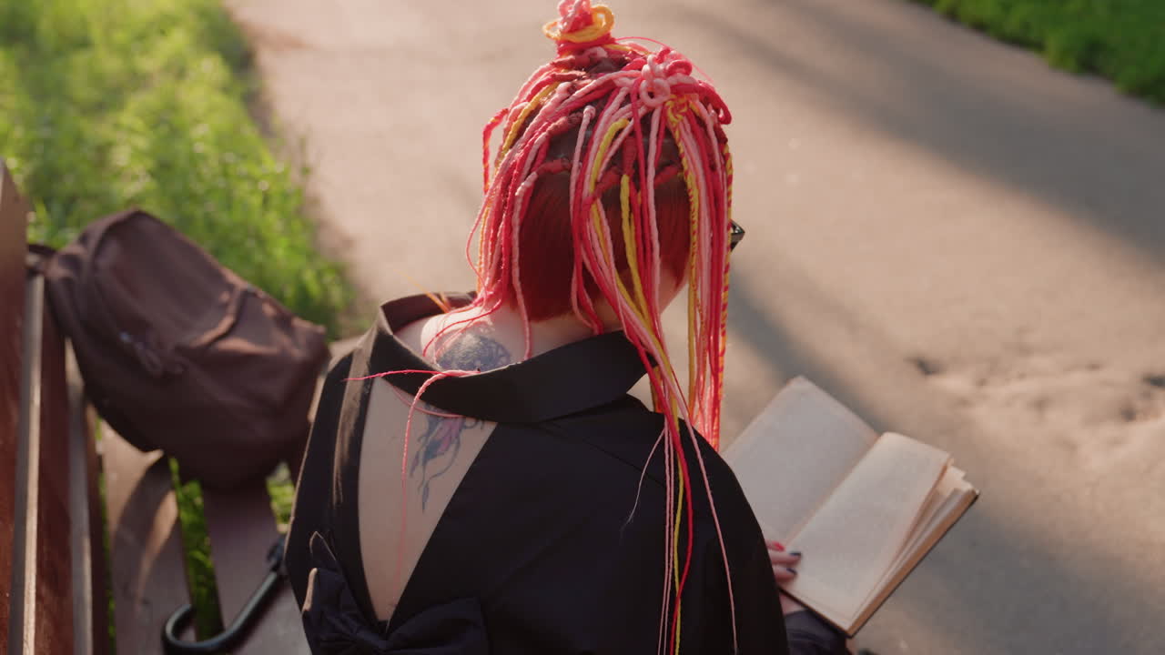 분홍색 땋은 머리를 한 야외 활동을 하는 학생, 햇볕 좋은 날을 즐기는 생기 넘치는 분홍색 머리의 젊은 대학생, 화창한 오후에 야외를 탐험하며 휴식을 취하는 다채로운 땋은 머리의 대학생